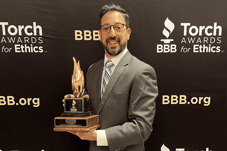 V2V President Daniel Rehal holds the 2024 BBB Torch Award for Ethics and Excellence